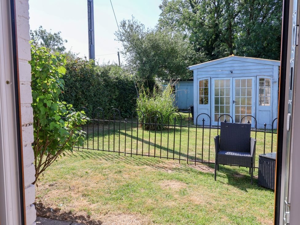 A garden with a fence and a shed at Coach House Highampton near Black Torrington
