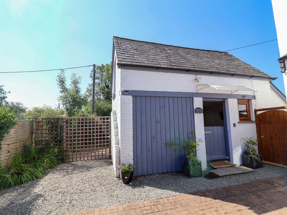 A building with a door and window with a gravel pathway at Coach House in Highampton near Black Torrington