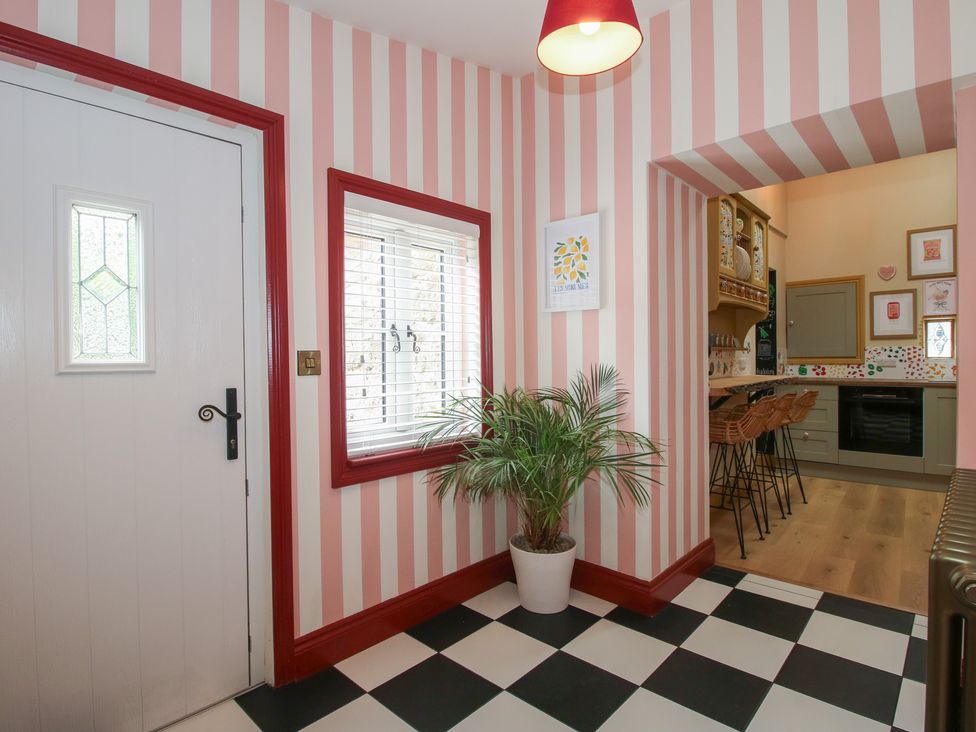 A hallway with a door and potted plant at The Dinky Dairy Treflach near Trefonen