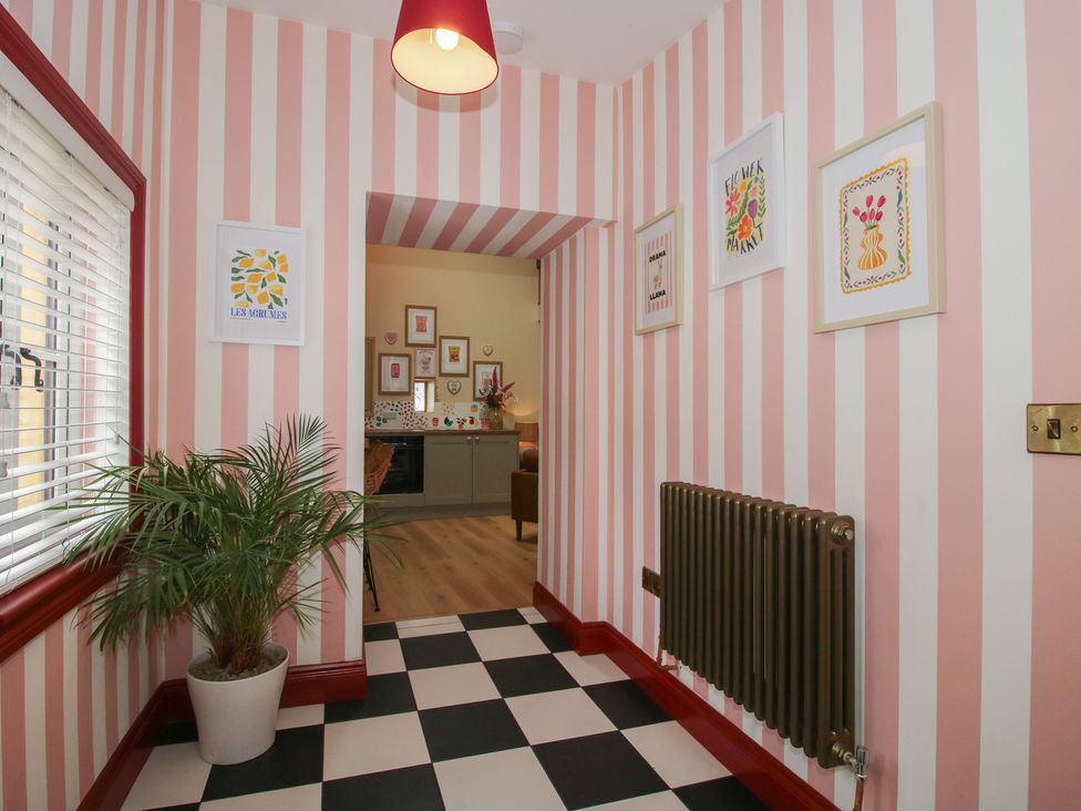 A hallway with wall art and a potted plant at The Dinky Dairy in Treflach near Trefonen