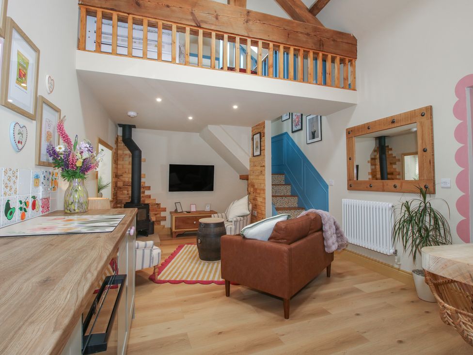 A living room with a sofa and staircase at The Dinky Dairy Treflach near Trefonen