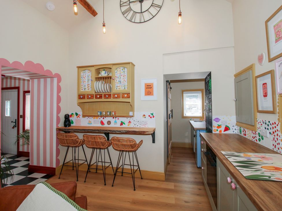 A kitchen with a countertop and bar stools at The Dinky Dairy in Treflach near Trefonen