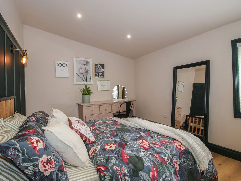 A bedroom with a bed and dresser at The Dinky Dairy Treflach near Trefonen