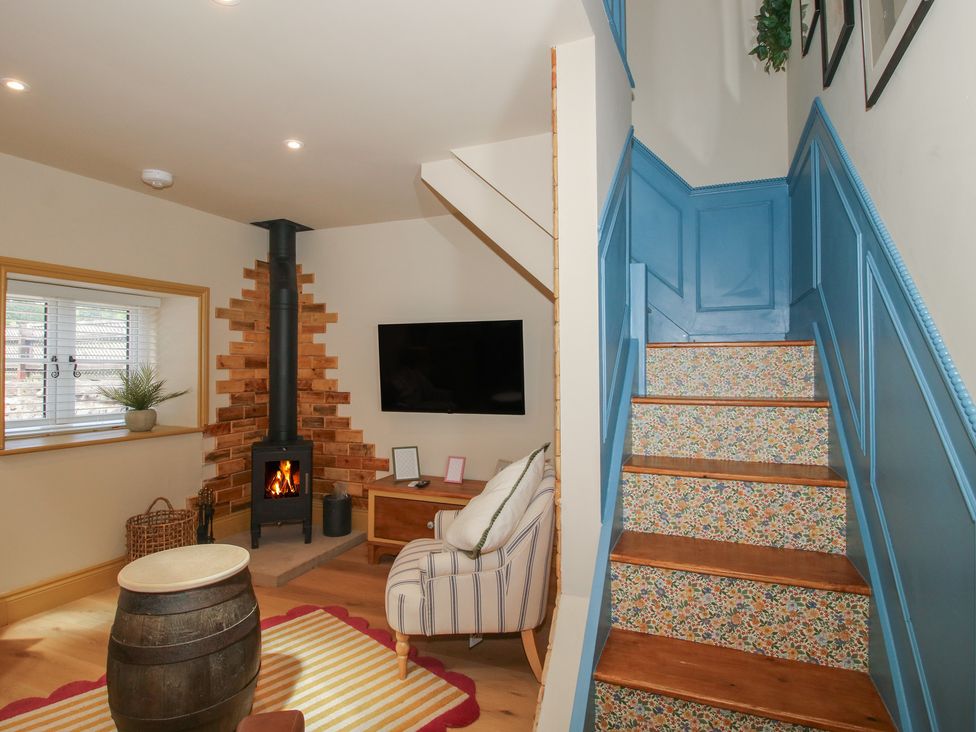 A living room with a fireplace and television at The Dinky Dairy Treflach near Trefonen