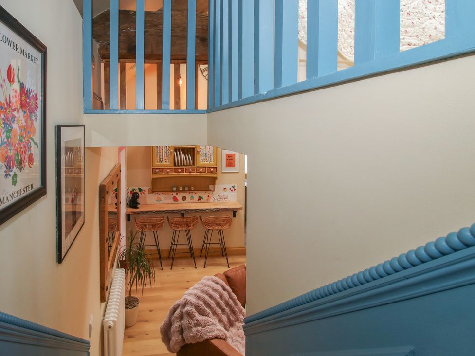 A staircase with a view of a kitchen area at The Dinky Dairy Treflach near Trefonen