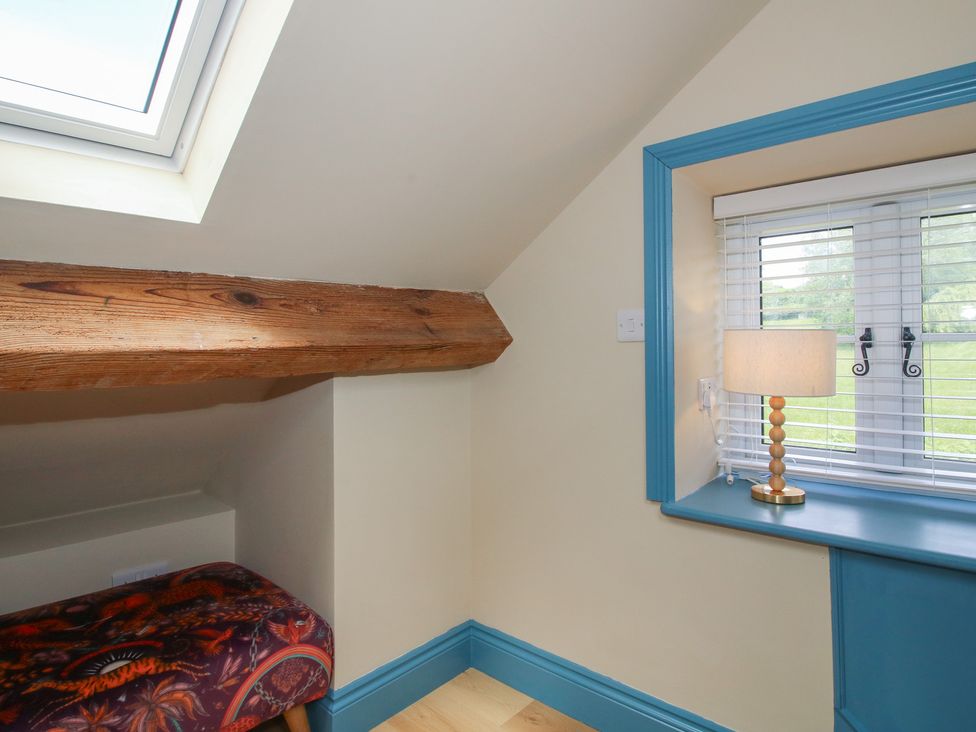 An attic space with a skylight and wooden beam at The Dinky Dairy in Treflach near Trefonen
