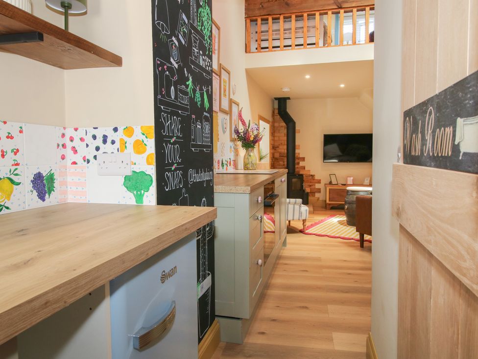 A kitchen with a countertop and blackboard wall at The Dinky Dairy Treflach near Trefonen