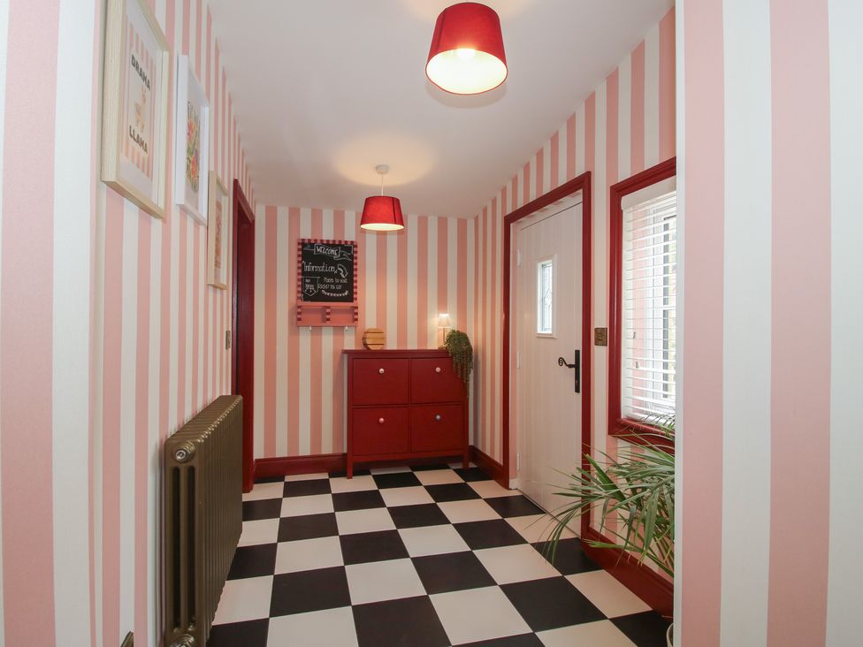 A hallway with a chest of drawers and a door at The Dinky Dairy in Treflach near Trefonen