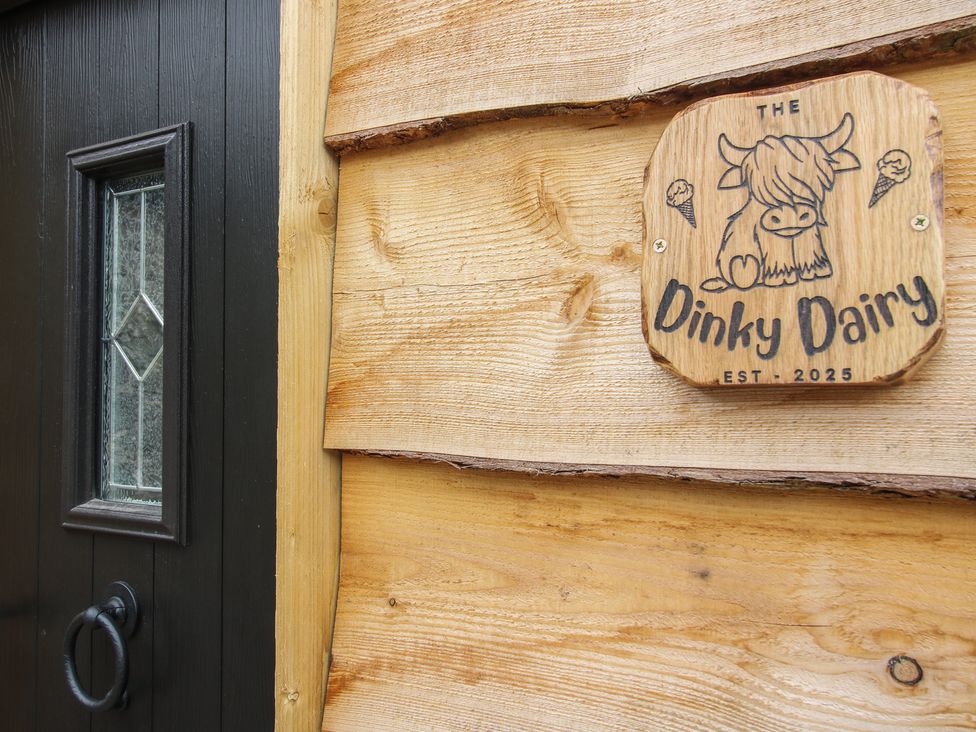 A door with a wooden sign at The Dinky Dairy in Treflach near Trefonen