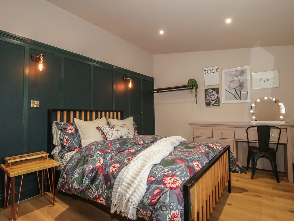 A bedroom with a bed and dressing table at The Dinky Dairy in Treflach near Trefonen