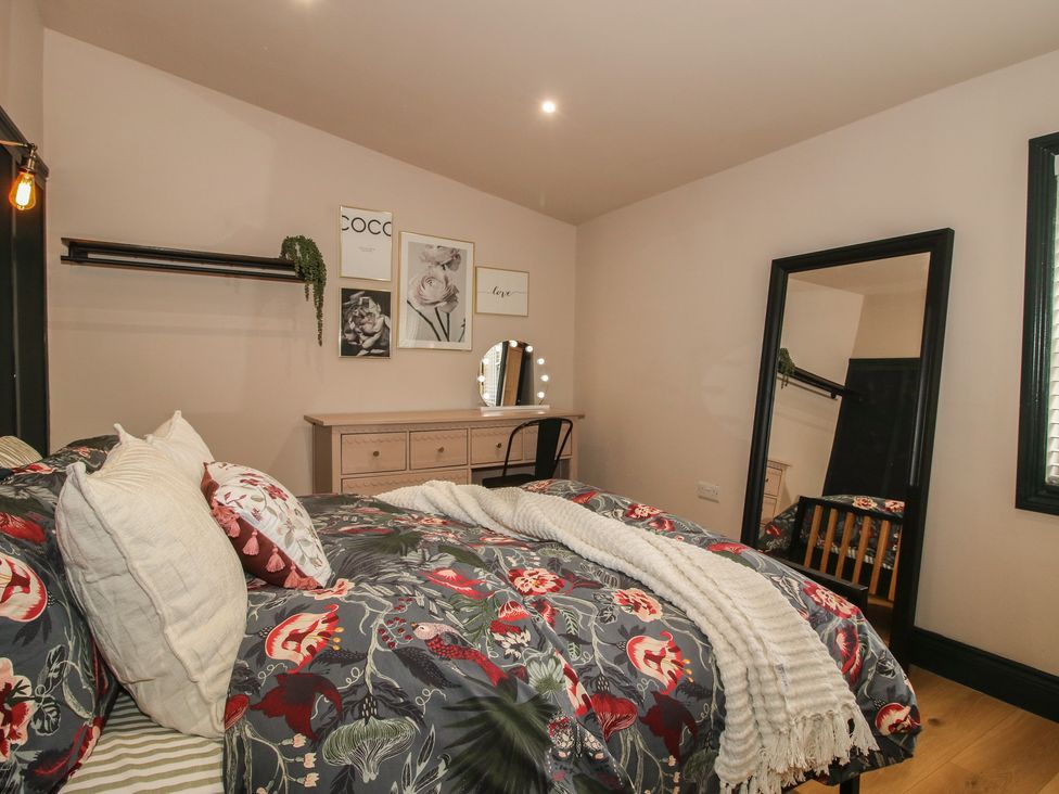 A bedroom with bed and dressing table at The Dinky Dairy in Treflach near Trefonen