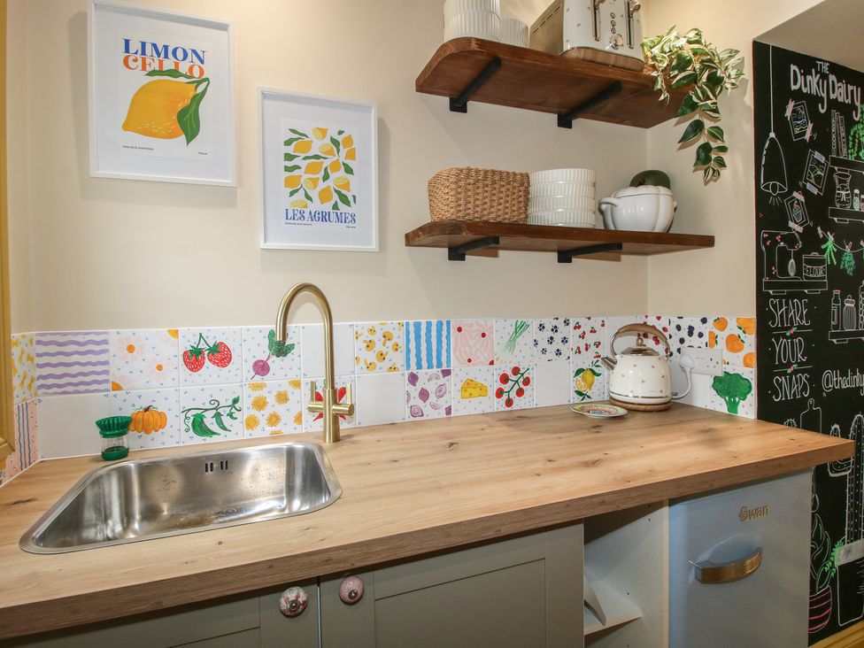A kitchen with sink and wall tiles at The Dinky Dairy in Treflach near Trefonen