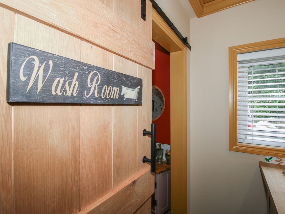 A wash room with a sliding door and window at The Dinky Dairy in Treflach near Trefonen