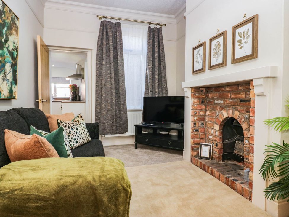 A living room with a sofa and a fireplace at 24 Harrington Road Workington