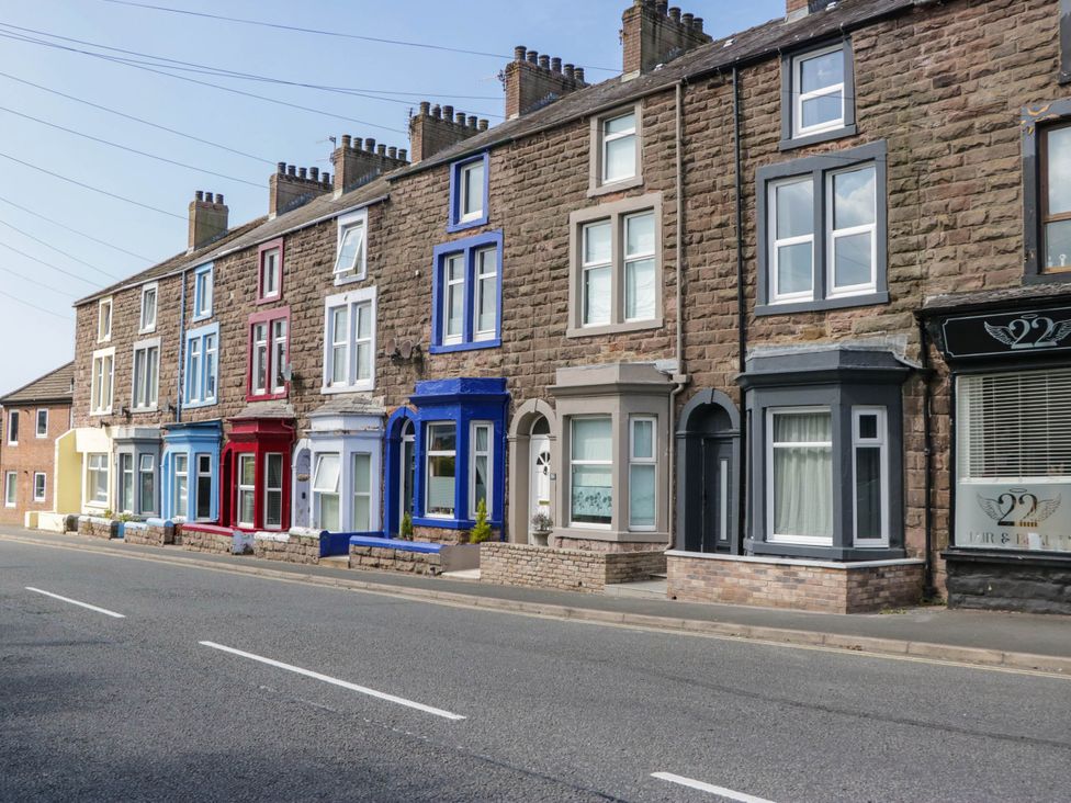 A row of houses with various colored facades at 24 Harrington Road Workington