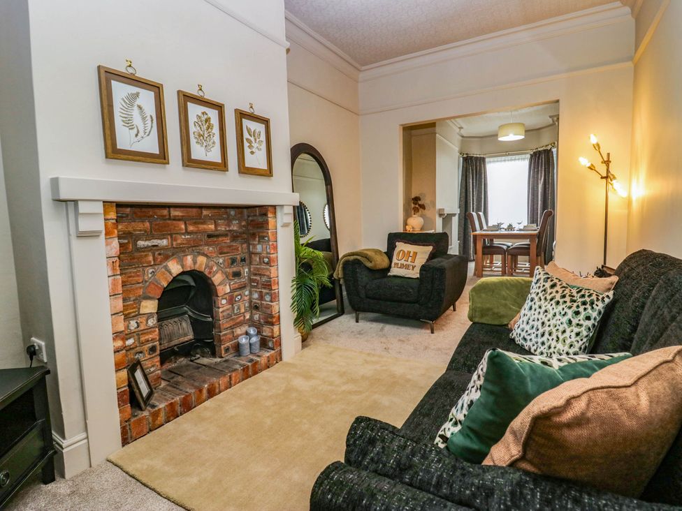 A living room with a sofa and fireplace at 24 Harrington Road in Workington