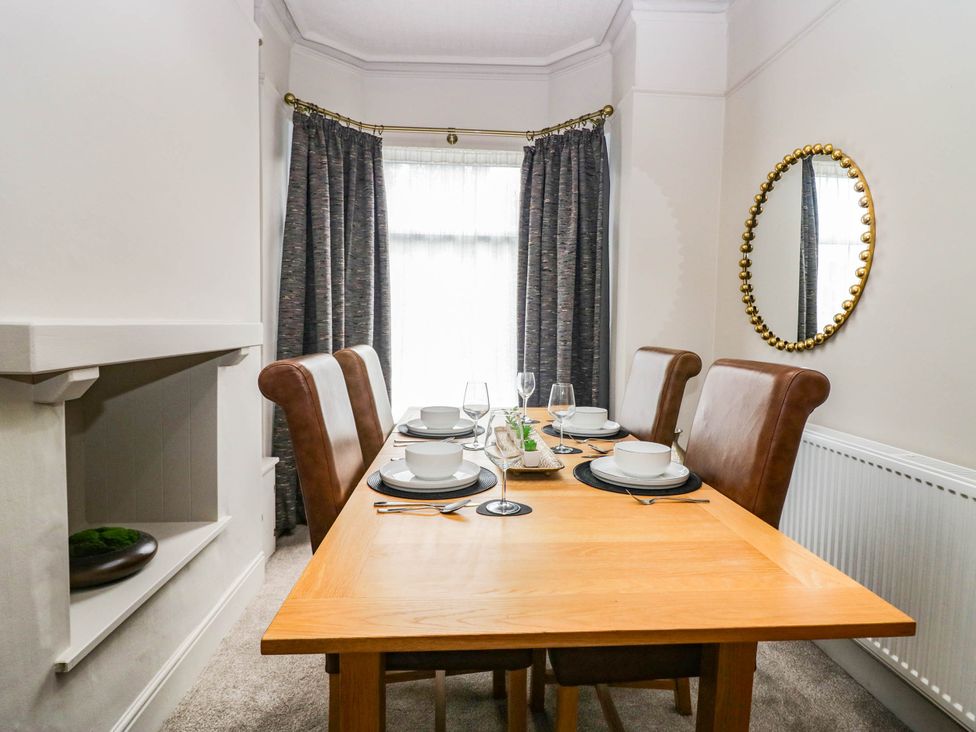 A dining room with a table set for meals at 24 Harrington Road Workington
