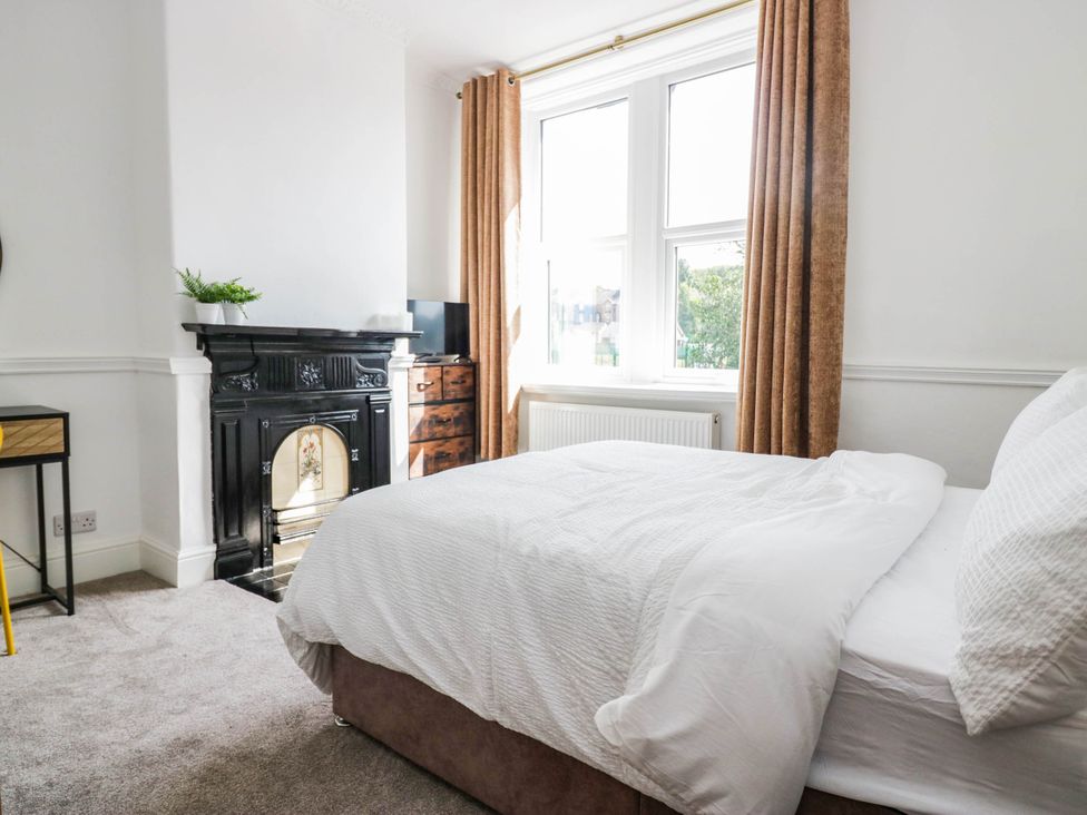 A bedroom with a bed and a fireplace at 24 Harrington Road in Workington