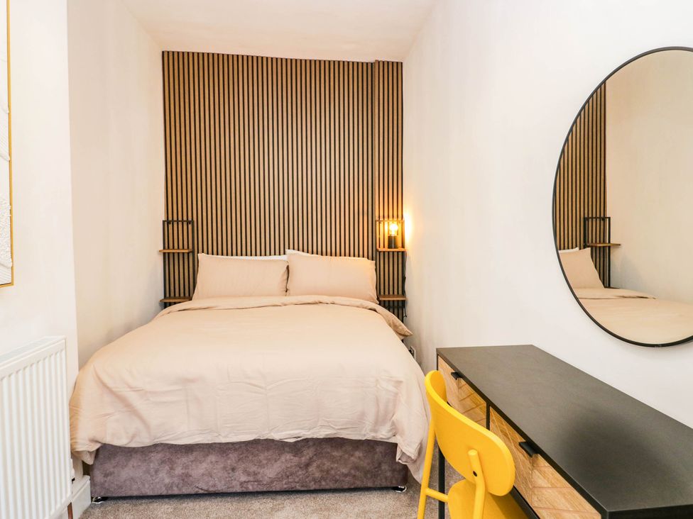 A bedroom with a bed and a dressing table at 24 Harrington Road in Workington