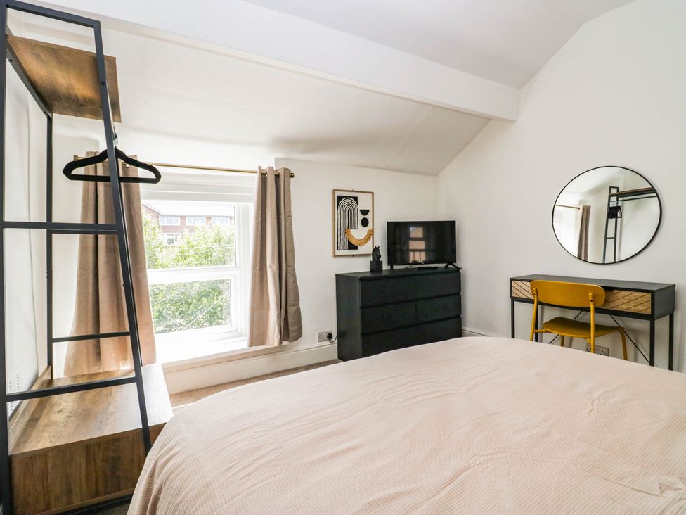 A bedroom with a bed, dresser, and mirror at 24 Harrington Road Workington