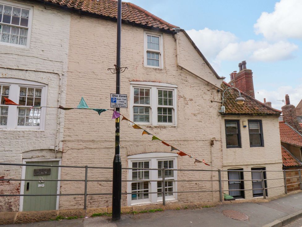 A building with windows and a door with a parking sign at Wick Cottage in Whitby