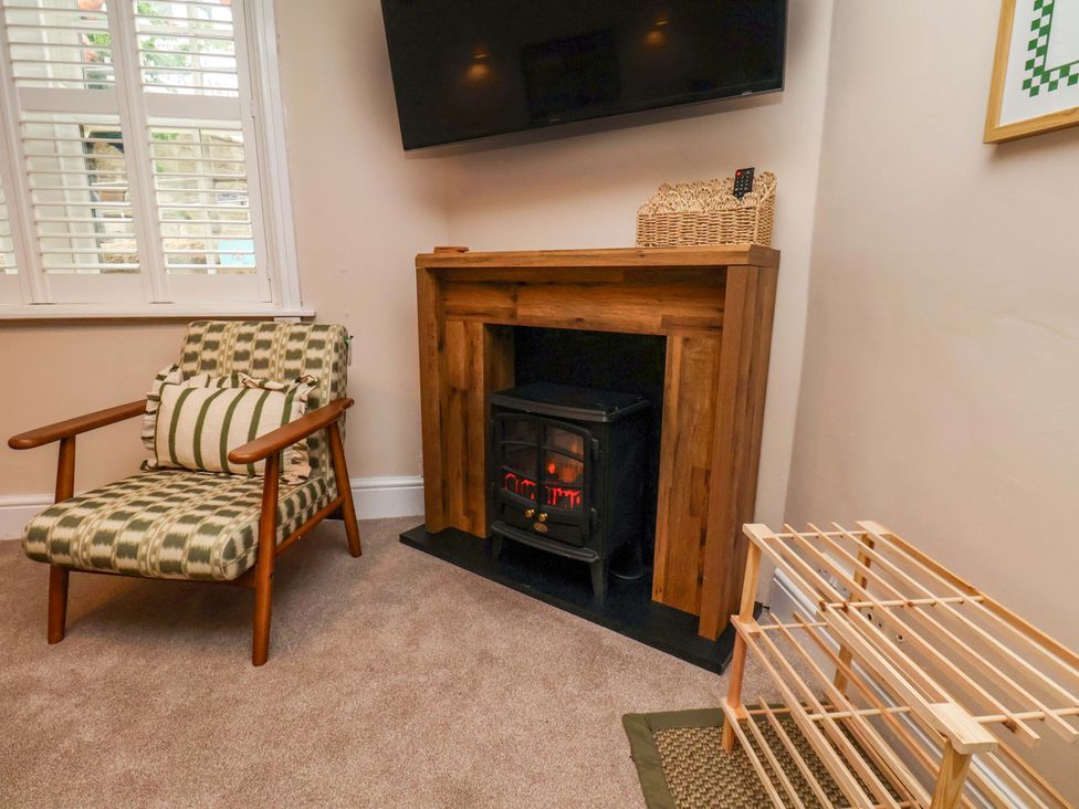 A living room with a fireplace and a chair at Wick Cottage in Whitby