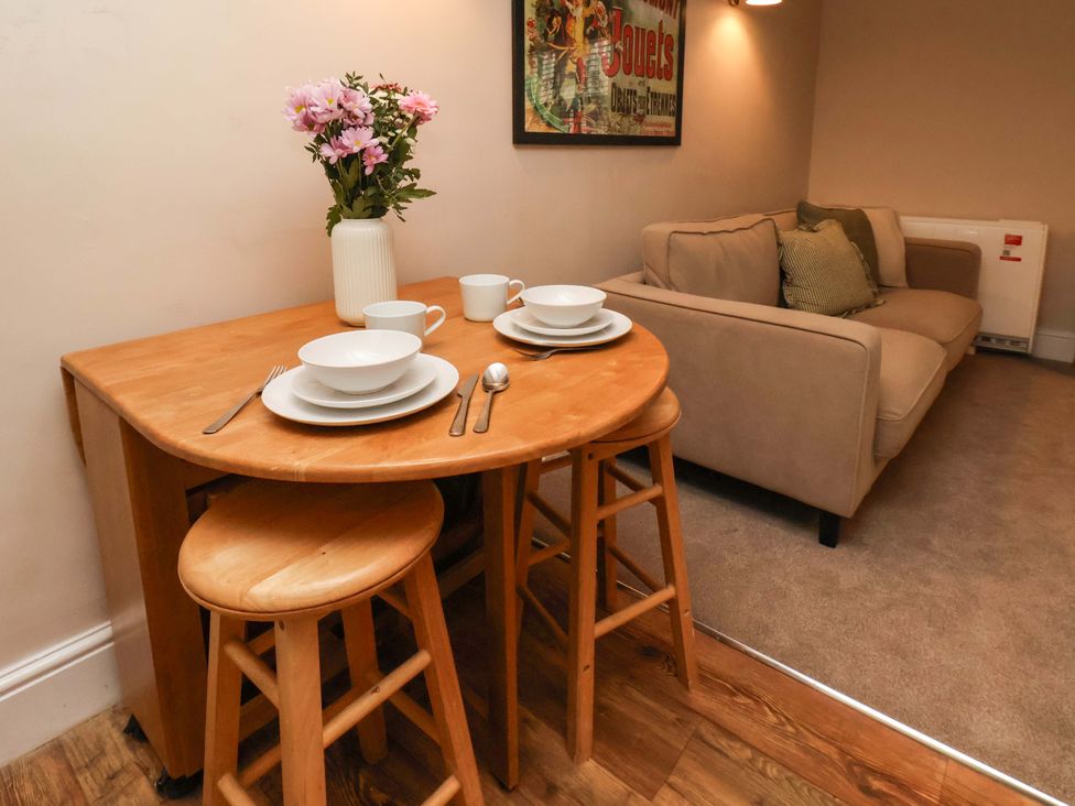 A dining area with a table and stools at Wick Cottage in Whitby