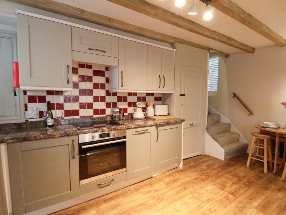A kitchen with cabinets and appliances at Wick Cottage in Whitby