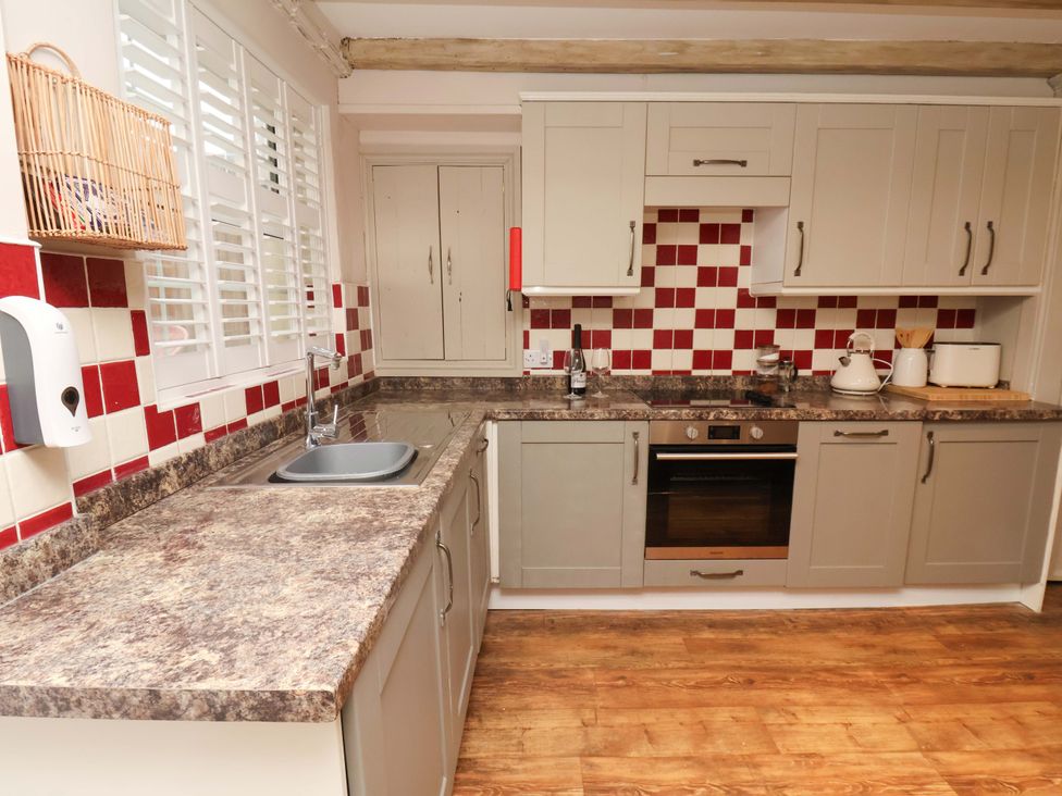 A kitchen with cabinets and appliances at Wick Cottage in Whitby