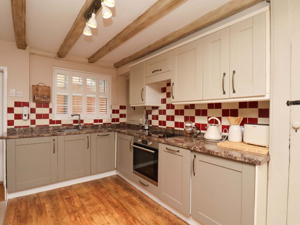 A kitchen with cabinets and appliances at Wick Cottage in Whitby