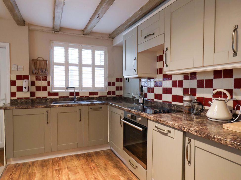 A kitchen with cabinets and appliances at Wick Cottage in Whitby