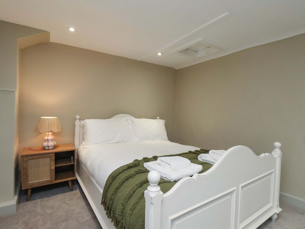 A bedroom with a bed and bedside lamp at Wick Cottage in Whitby
