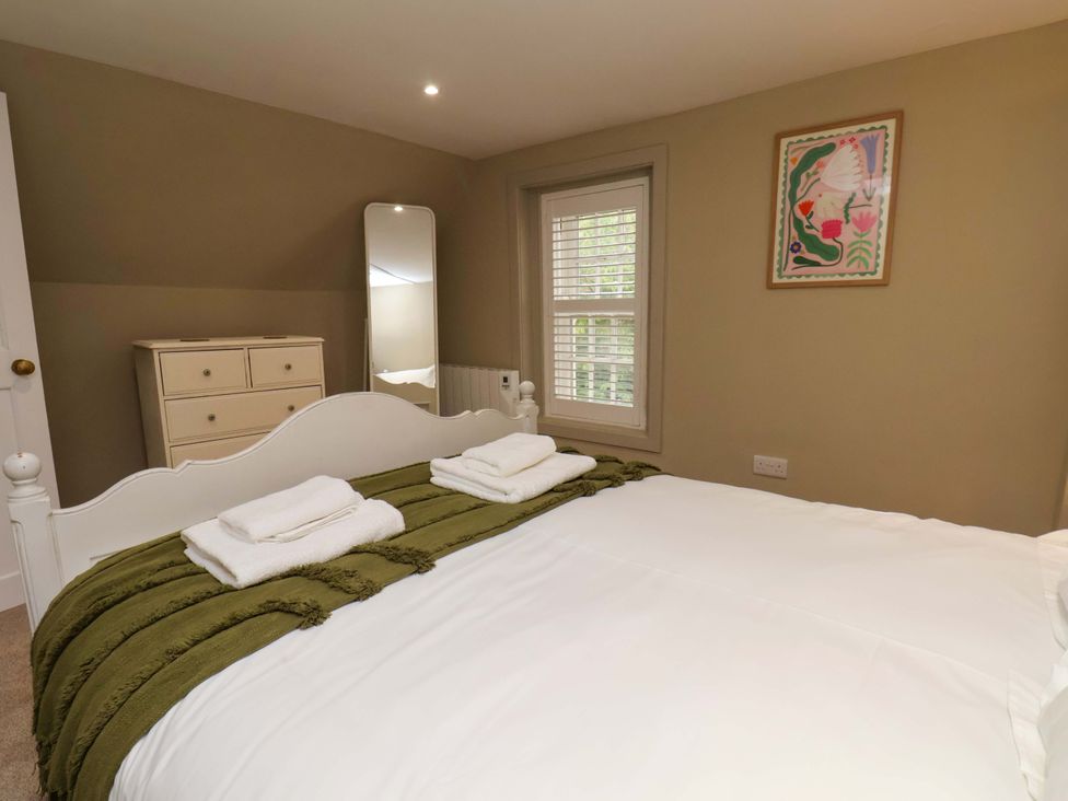 A bedroom with a bed and dresser at Wick Cottage in Whitby