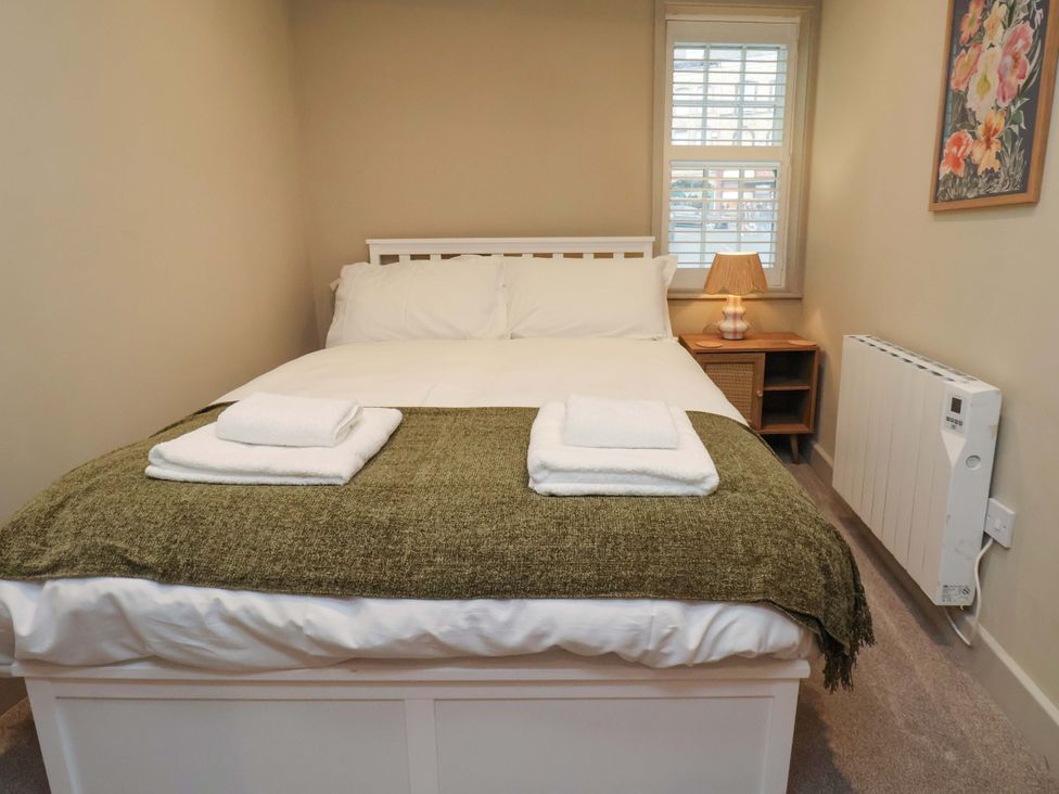 A bedroom with a bed and a lamp at Wick Cottage in Whitby
