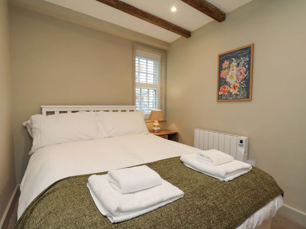 A bedroom with a bed and lamp at Wick Cottage in Whitby