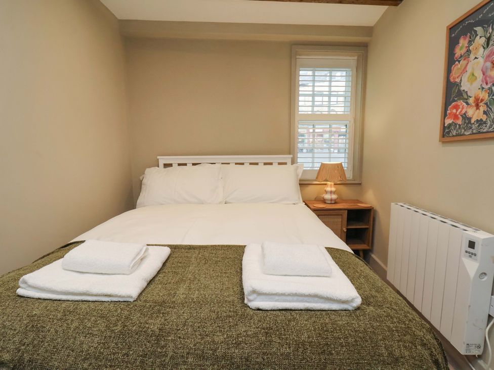 A bedroom with a bed and bedside table at Wick Cottage in Whitby