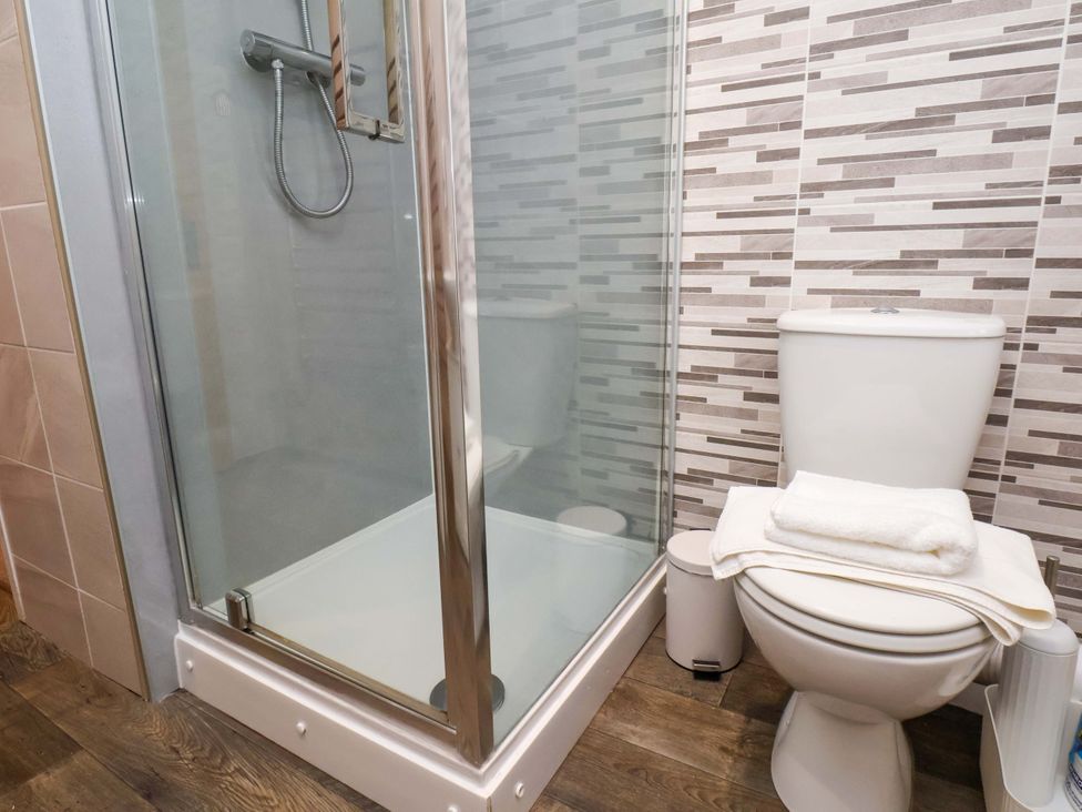 A bathroom with a shower and a toilet at Wick Cottage in Whitby