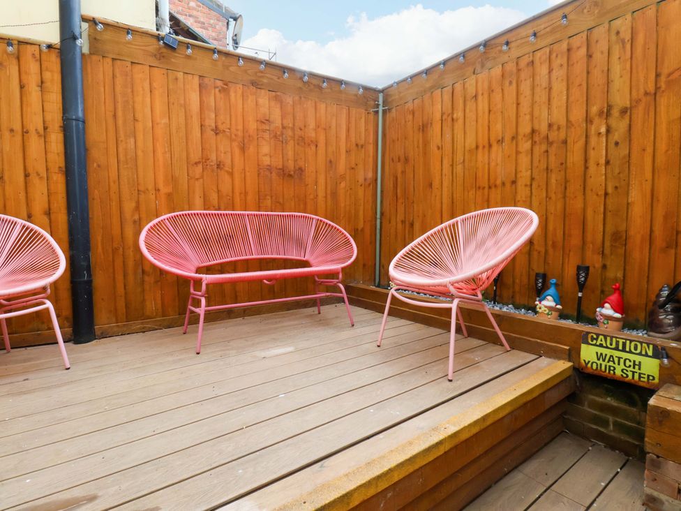 A garden area with wooden flooring and chairs at Wick Cottage in Whitby