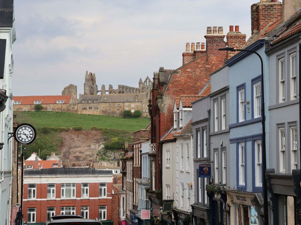 A street view with buildings and ruins in the background at Wick Cottage in Whitby