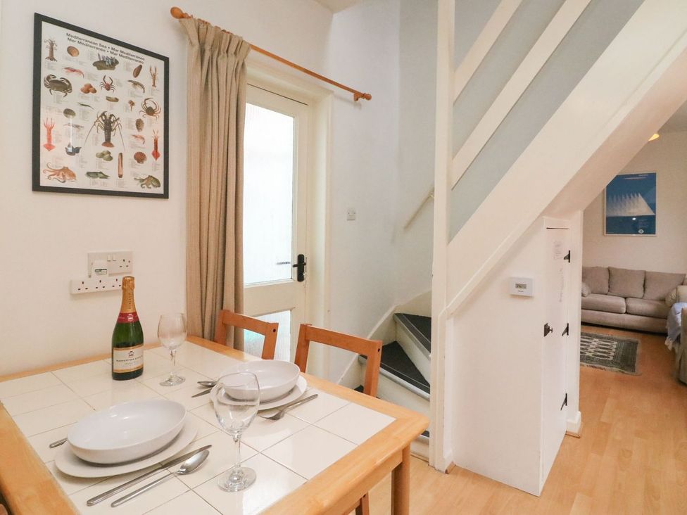 A dining room with a table and chairs at Pixie Cottage in Weymouth