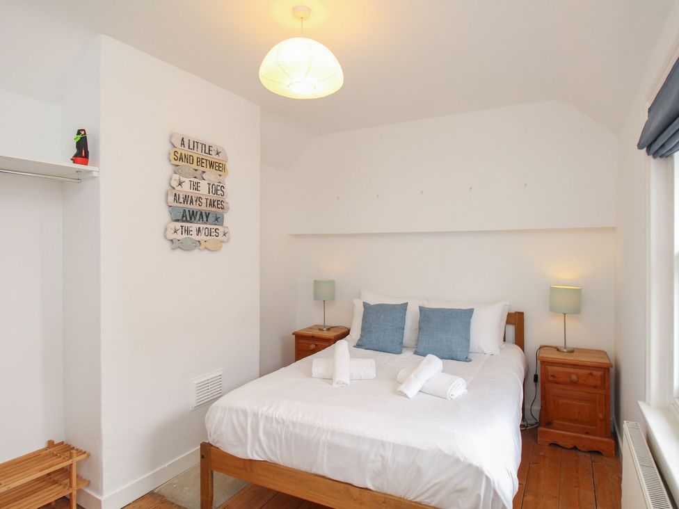 A bedroom with a bed and bedside tables at Pixie Cottage in Weymouth
