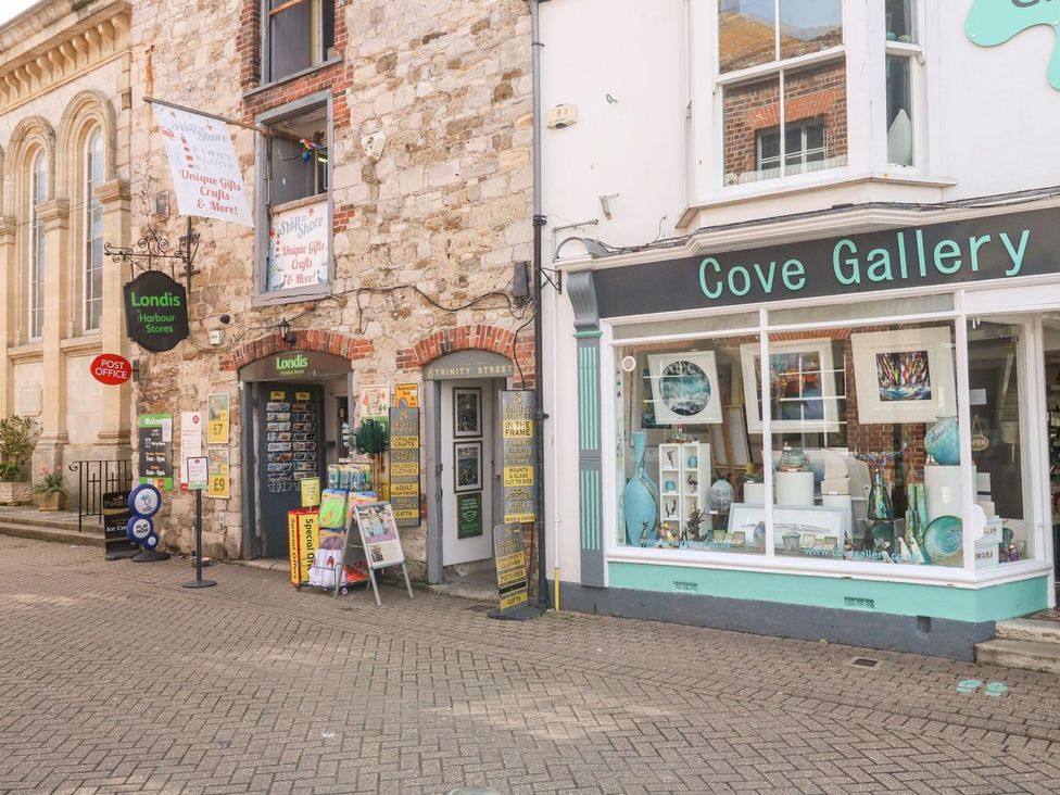 An outdoor shopfront with Londis Harbour Stores and Cove Gallery at Pixie Cottage Weymouth