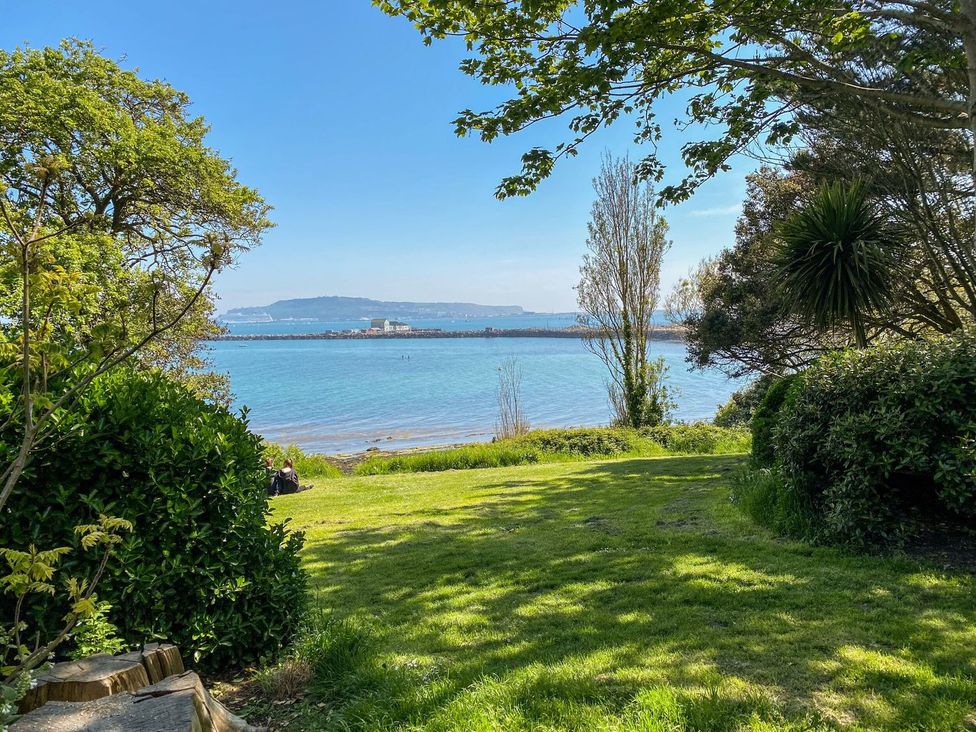 A view of water and trees from a garden at Pixie Cottage in Weymouth