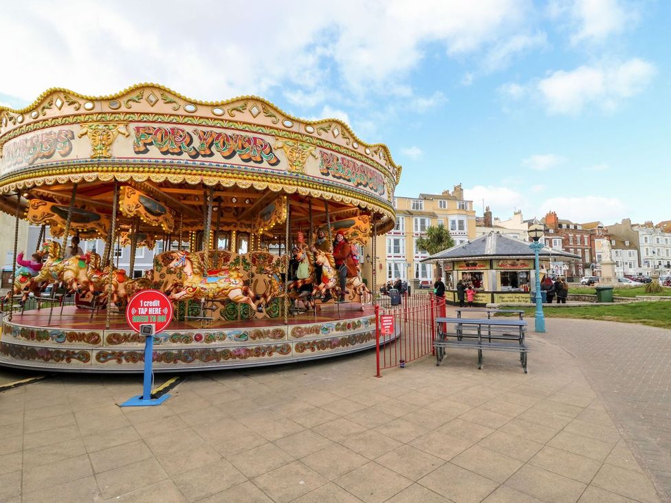 A carousel with horses and benches at Pixie Cottage in Weymouth