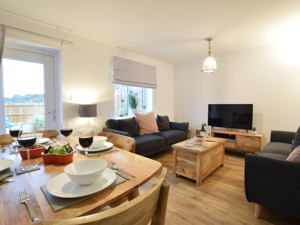 A living room with a sofa and television at Lapwings, Aldeburgh