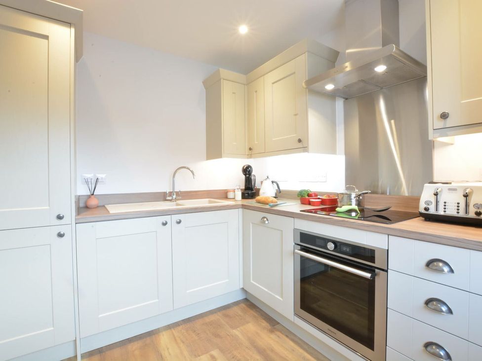 A kitchen with cabinets, sink and stove at Lapwings, Aldeburgh
