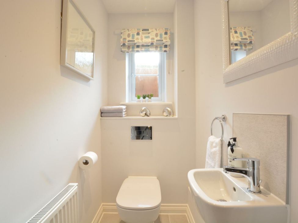 A bathroom with a toilet and sink at Lapwings, Aldeburgh