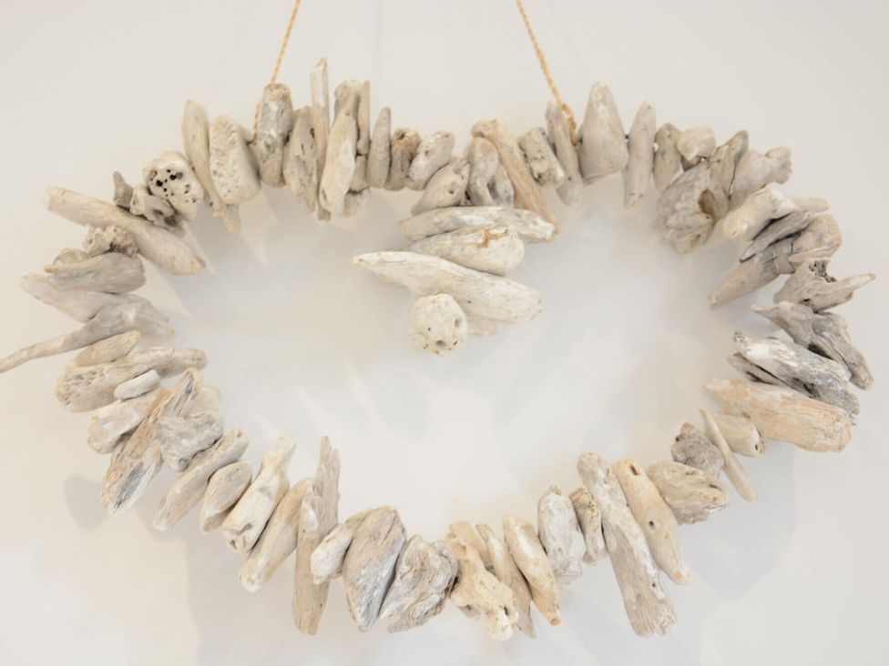 A circular driftwood decoration hanging on a wall at Lapwings, Aldeburgh