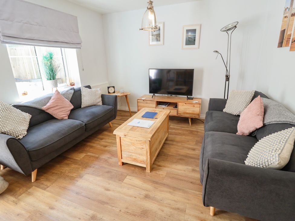 A living room with sofas and a television at Lapwings, Aldeburgh