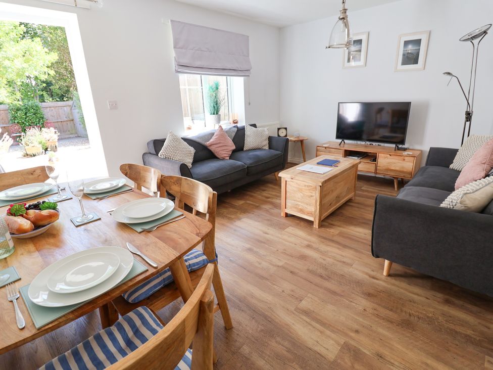 A living room with a dining table and sofas at Lapwings, Aldeburgh